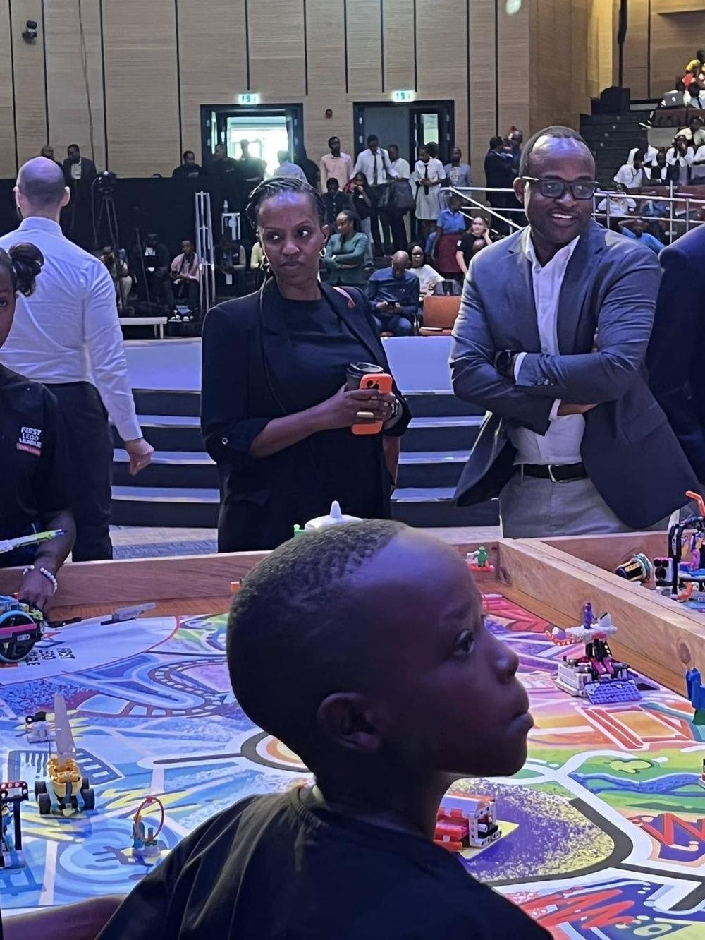 Learners and staff at a FIRST LEGO League competition, robots on the mat
