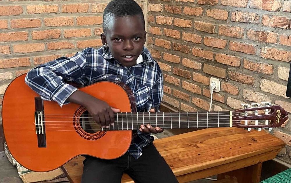 A Bright School pupil playing a classical guitar during a music lesson
