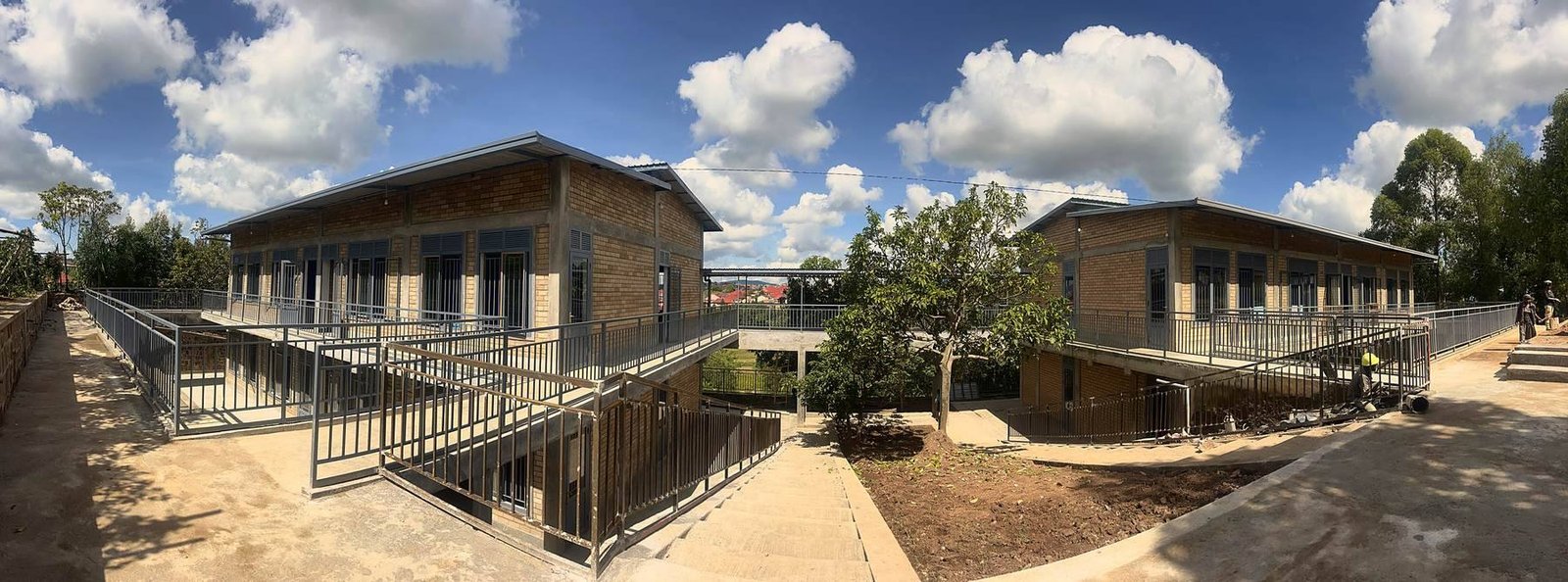Panorama of the two Bright School blocks and the ramp between them, under a blue sky