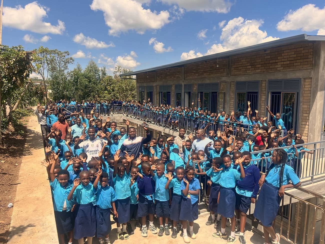 Bright School learners waving from the ramp and balcony of their school