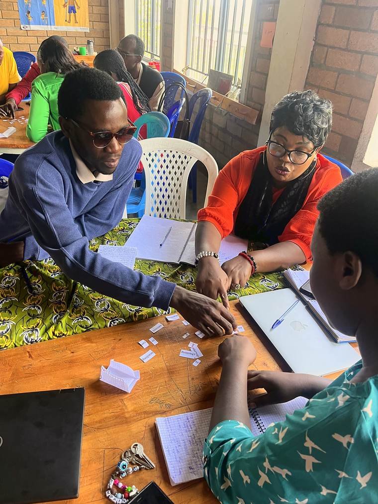 Teachers gathered around a table of word cards and notebooks