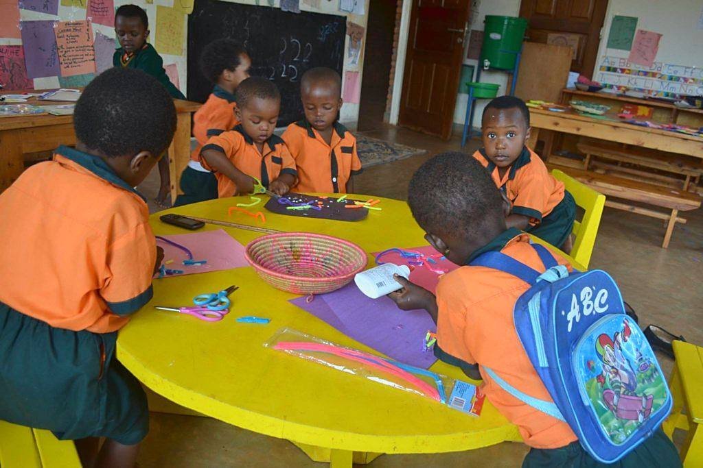 Learners making with coloured pipe cleaners around a yellow table