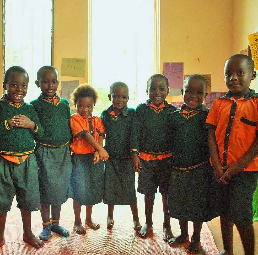 Seven Harmony School learners standing together in their uniforms, smiling