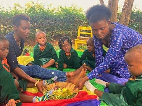 A teacher and learners exploring a basket of leaves outdoors