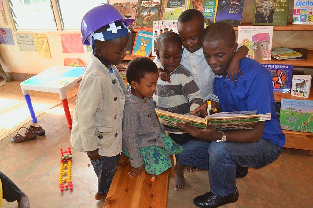 A teacher reading a picture book with a group of children