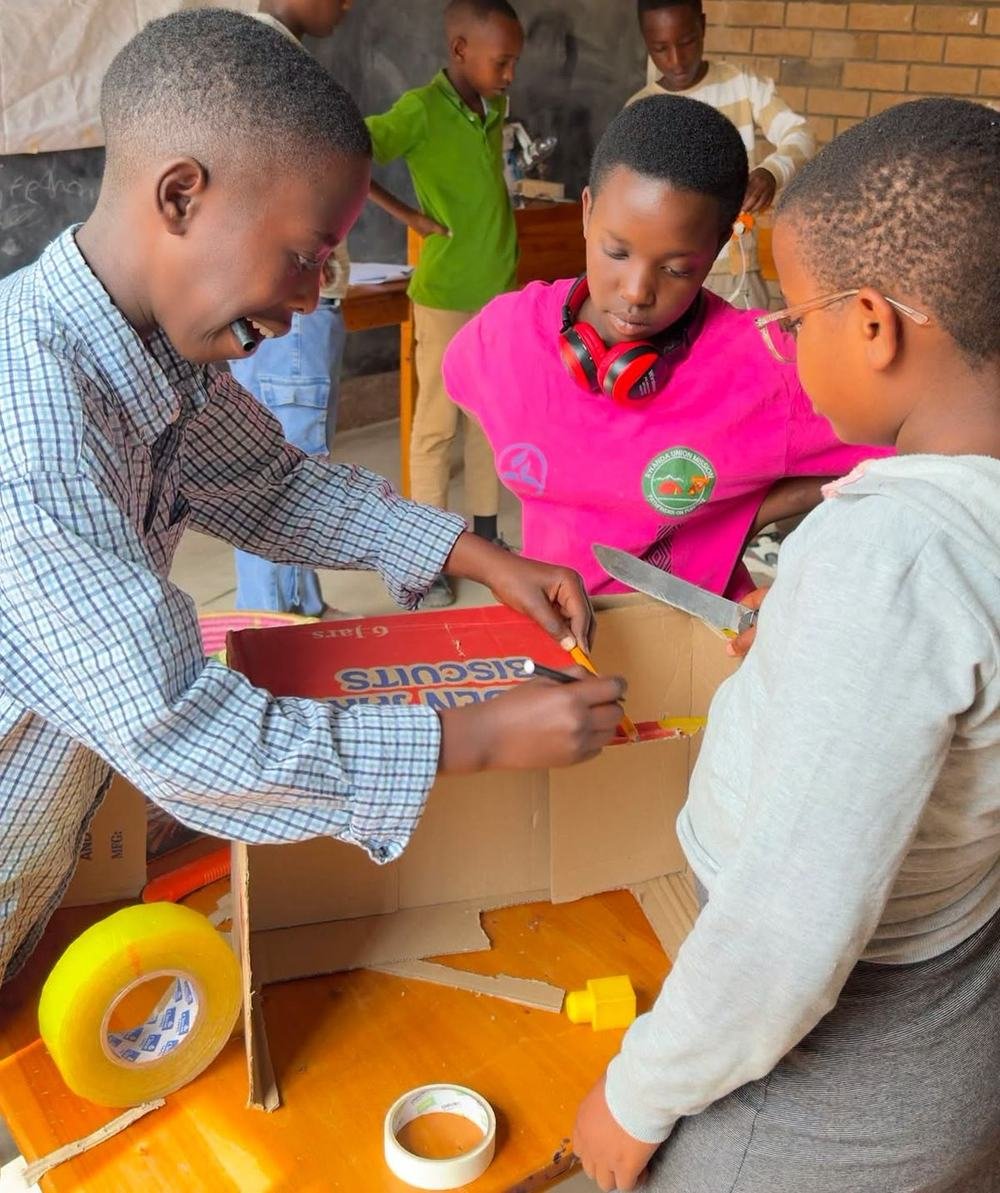 Learners building a robot body from a cardboard box