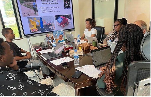 A planning meeting with the robotics curriculum shown on screen