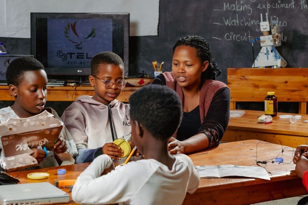 A facilitator guiding learners building STELA Eco-Bots from recycled materials