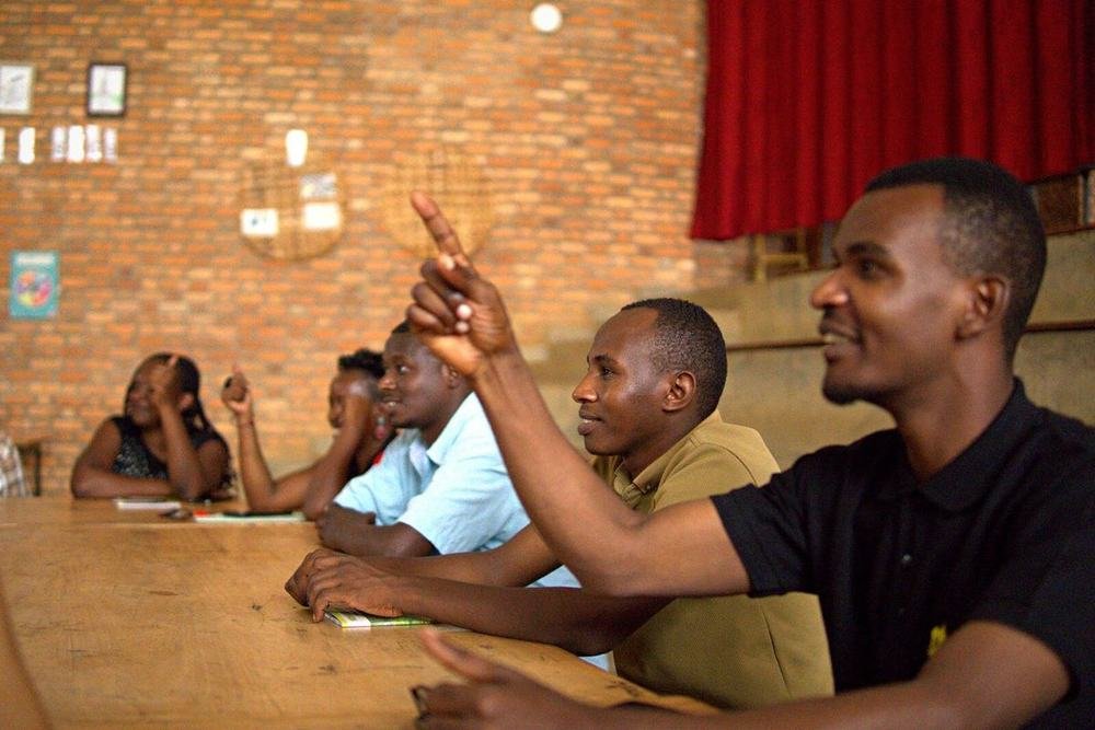 A teacher raising a hand to answer during a workshop discussion
