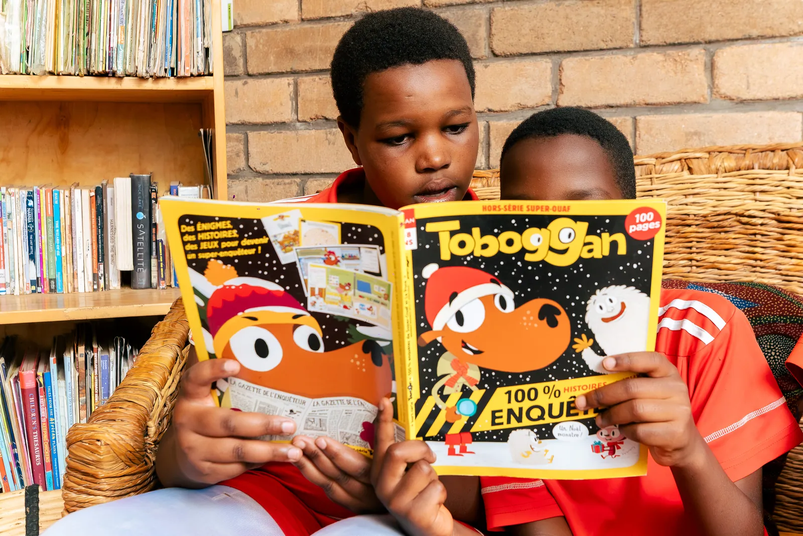 A child reading a bright illustrated magazine in the library